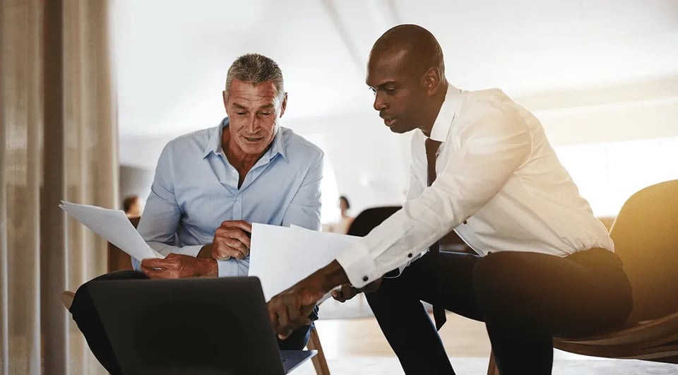 two-young-men-studying-data-on-laptop